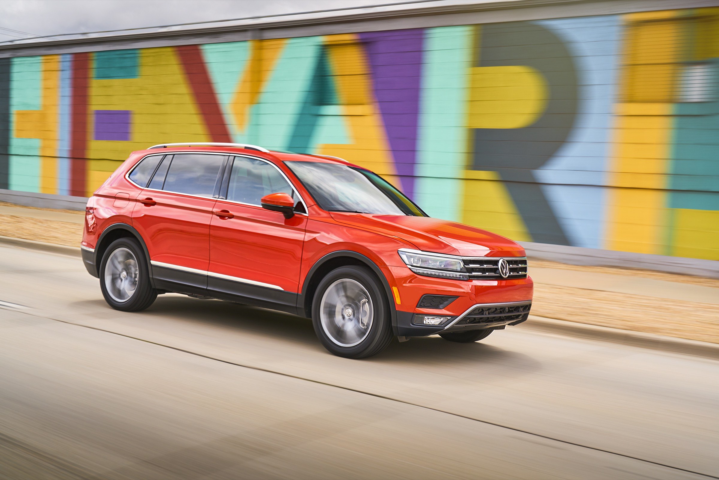 2018 Volkswagen Tiguan SEL Premium in orange, front three-quarter driving view, the second-generation long-wheelbase Tiguan that makes up the largest group in recall 26V590000 over a steering rack bolt that can corrode and break