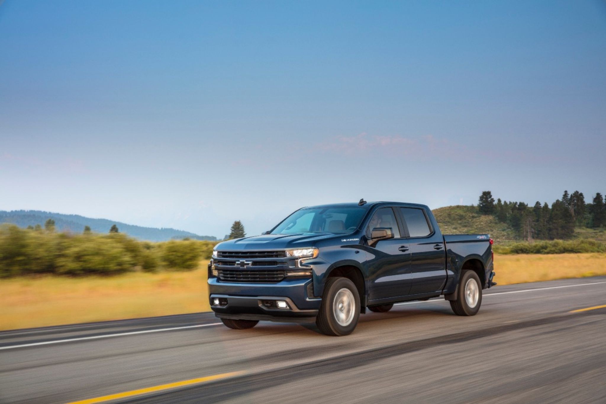 2021 Chevrolet Silverado 1500 RST driving on a rural highway, one of the trucks recalled for the front center seat belt bracket issue