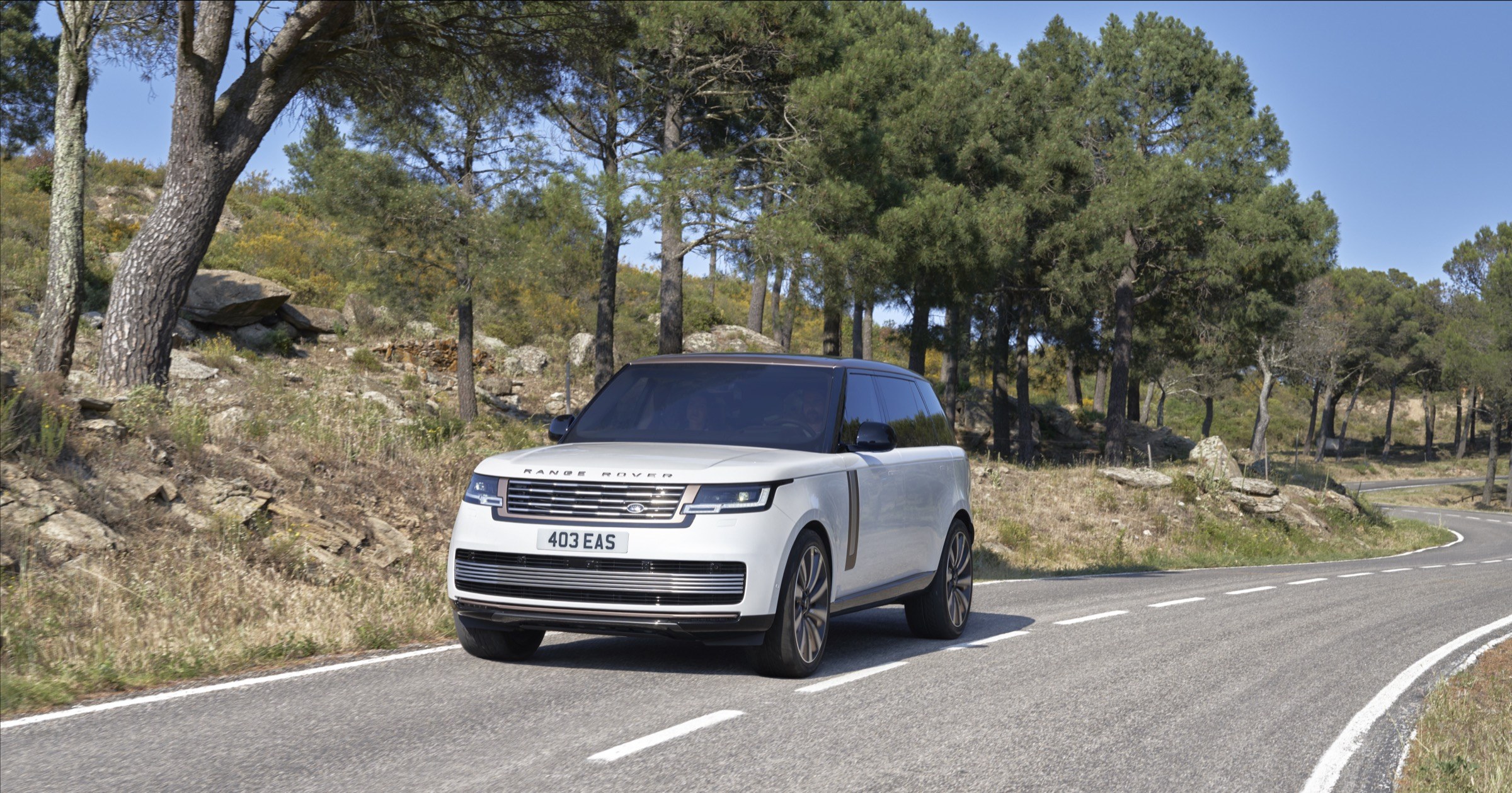 Land Rover Range Rover SV long-wheelbase in white on a mountain road, front three-quarter view of the current body style covered by recall 26V678000 over water damage to the tailgate rearview camera, European model shown