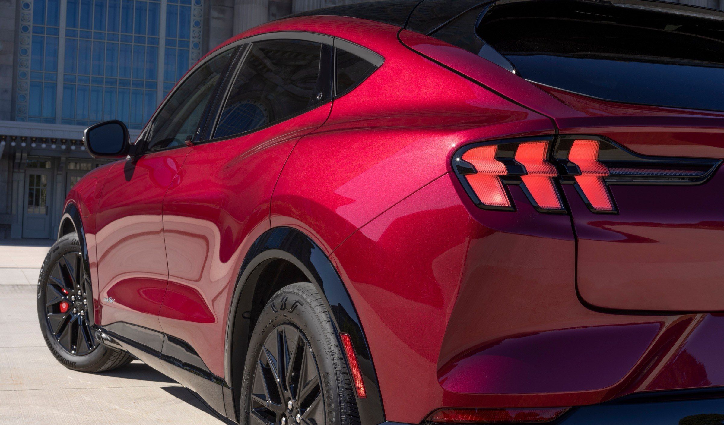 2025 Ford Mustang Mach-E rear three-quarter view showing the rear side quarter window and its black trim surround, the component covered by recall 26V487000