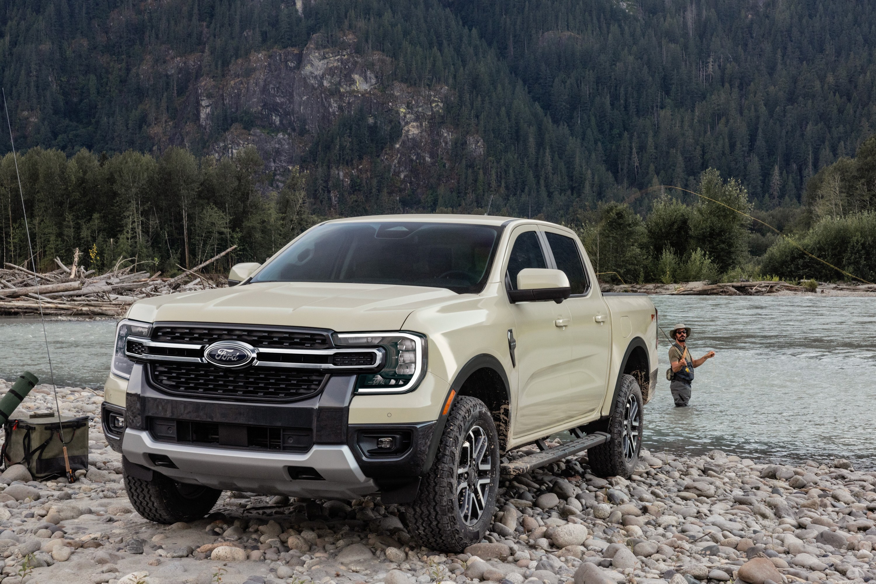 2026 Ford Ranger Lariat in Desert Sand parked on a rocky riverbank, front three-quarter view, the model year covered by recall 26V605