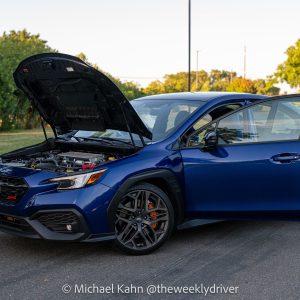 2025 Subaru WRX tS in blue with its hood up and doors open
