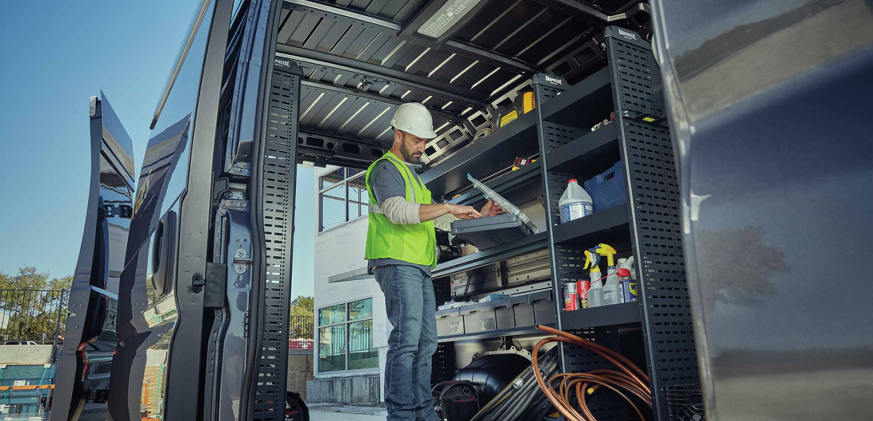 2025 RAM ProMaster cargo area configured with shelves, laptop workstation, and organized tools for a mobile technician