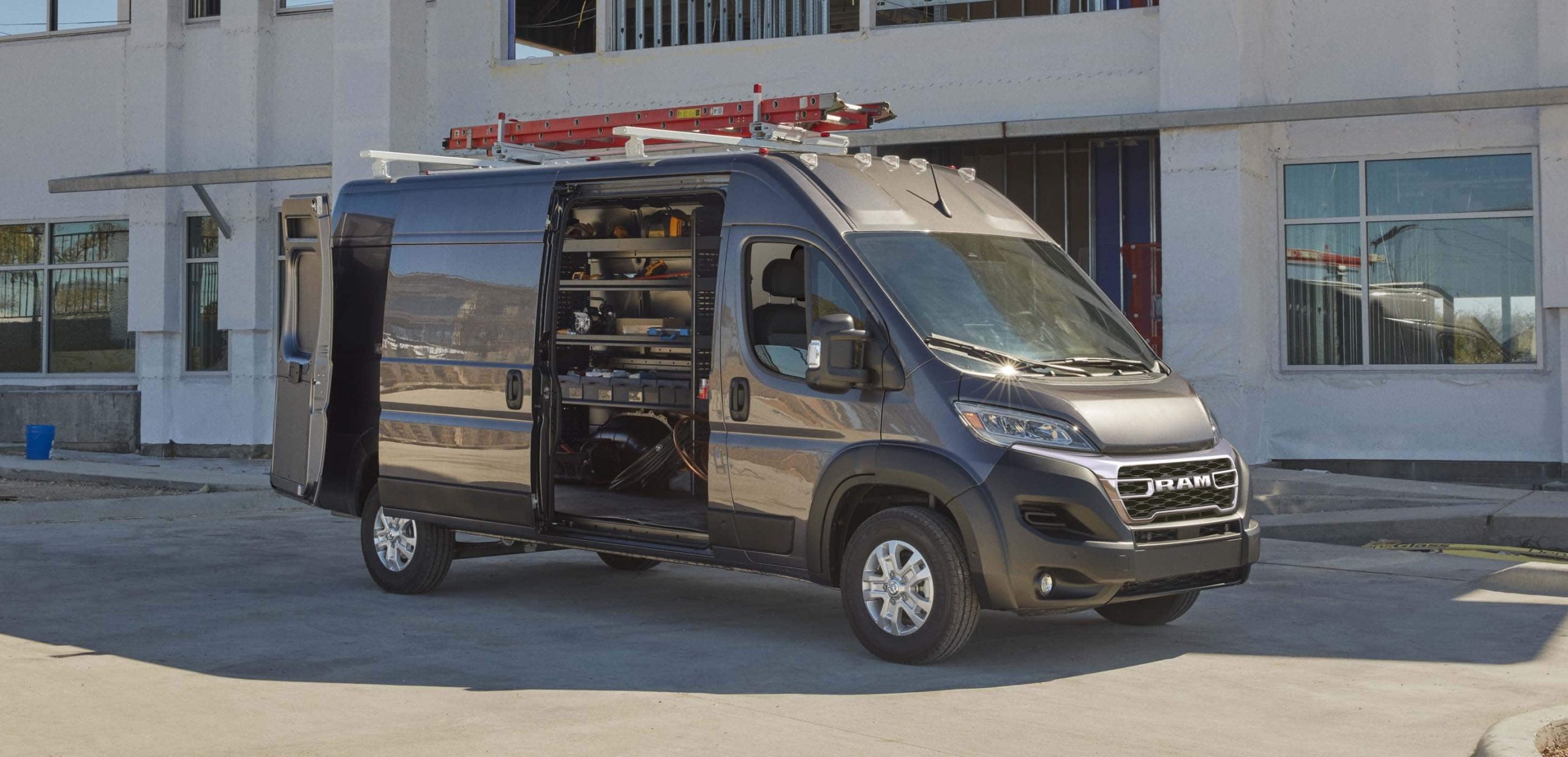 2025 RAM ProMaster 2500 SLT in gray with sliding door open and aftermarket ladder rack installed
