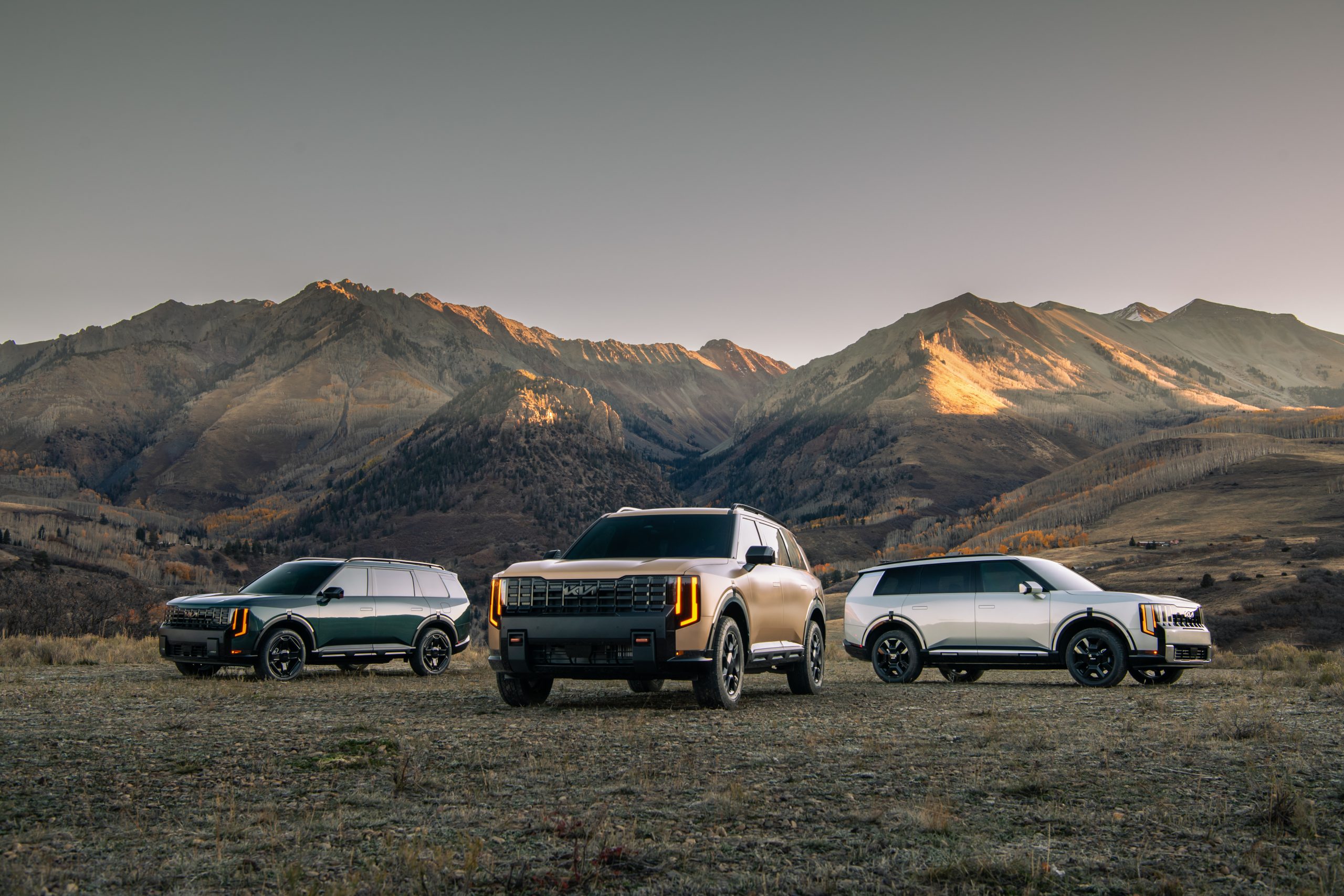2027 Kia Telluride X-Line, X-Pro, and SX-Prestige lineup photographed in a mountain meadow at golden hour
