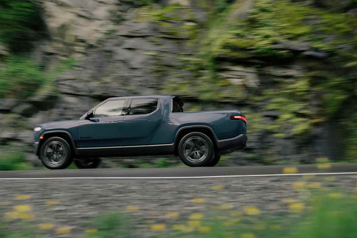 Rivian's 2026 Lineup: Every Model, Every Price, and Which One to Buy 1 2026 Rivian R1T blue side profile driving on mountain road
