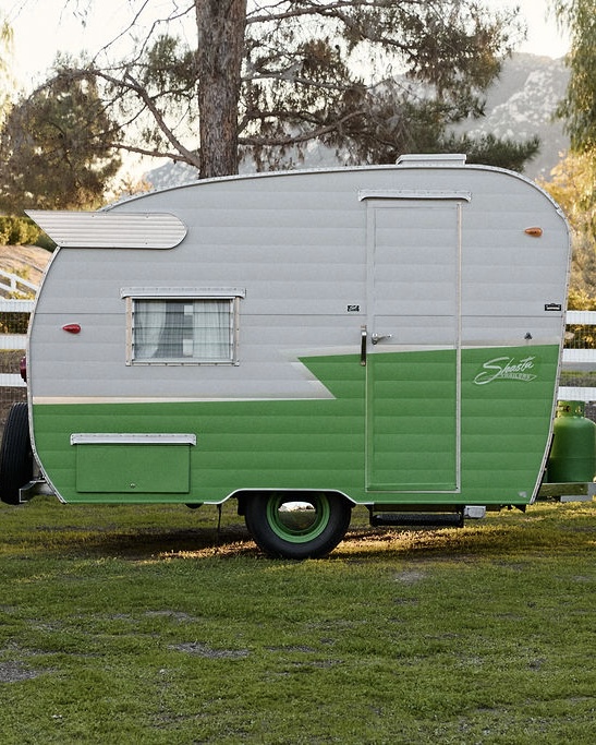 1960 Shasta Compact camper trailer in silver and green, profile view
