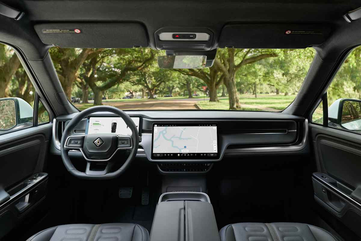 2026 Rivian R1S Gen-2 interior cockpit with large touchscreen and live oak trees visible through windshield