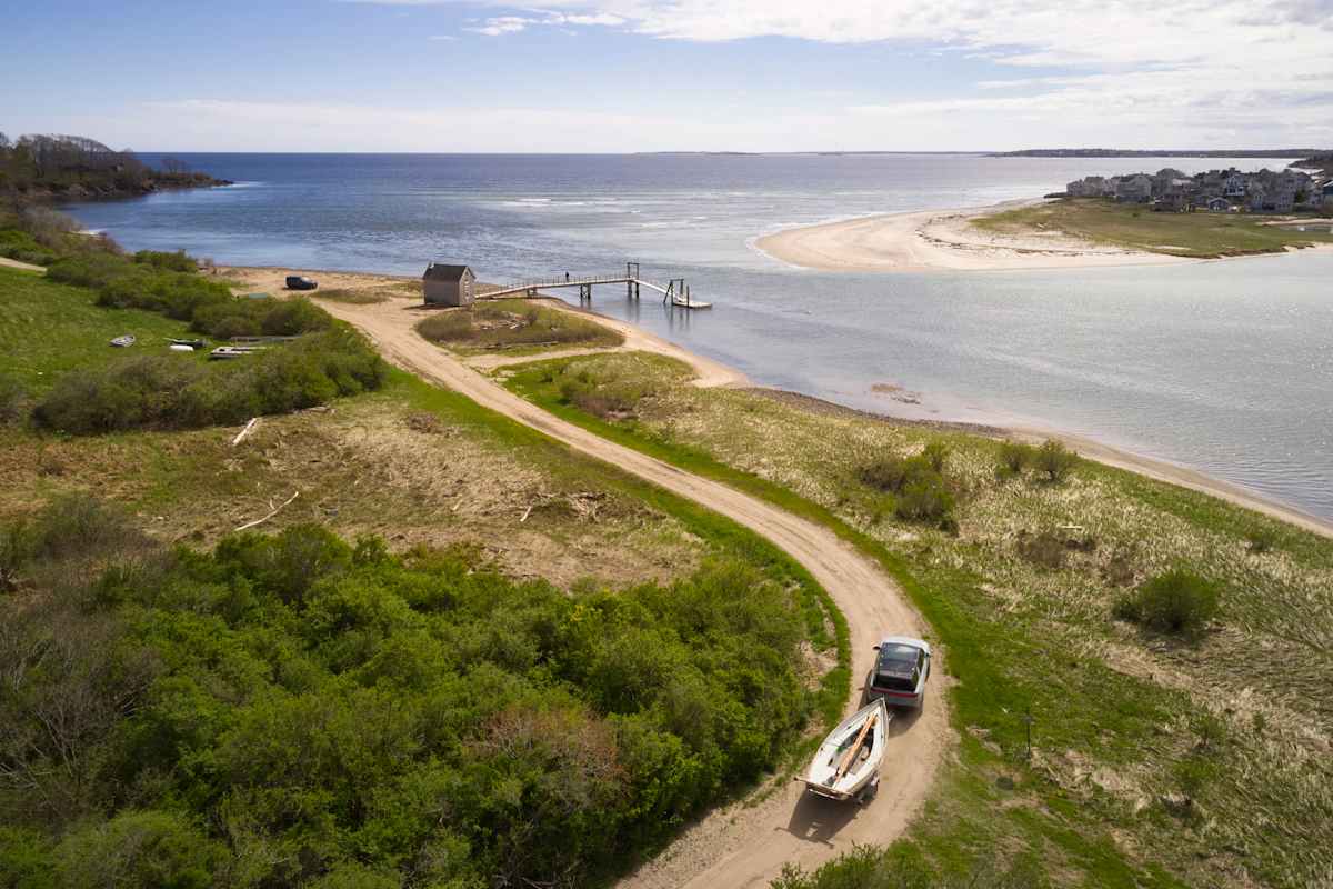 Rivian Reliability in 2026: What Three Years of R1T and R1S Owner Data Shows 1 2026 Rivian R1S aerial view on coastal dirt road with kayak on roof rack