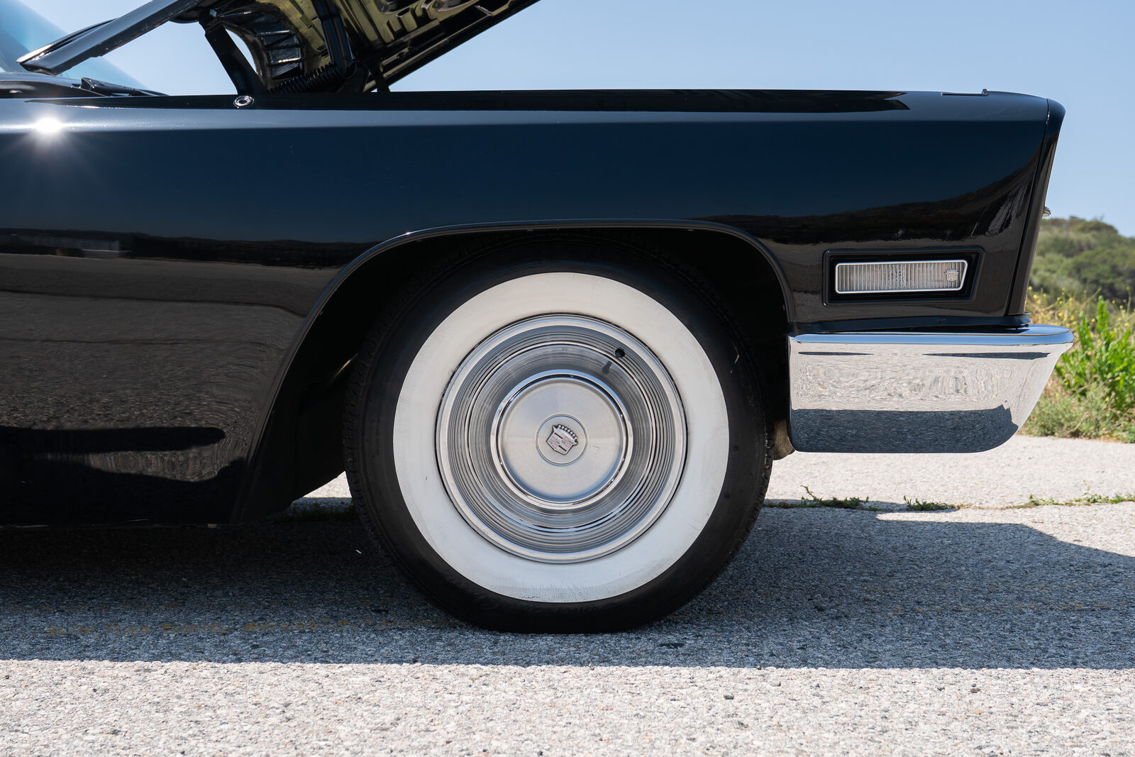 Whitewall radial tire on the stock steel wheel with full Cadillac wheel cover on the black 1968 Coupe DeVille