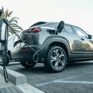 Electric vehicle plugged into a public charging station in daylight