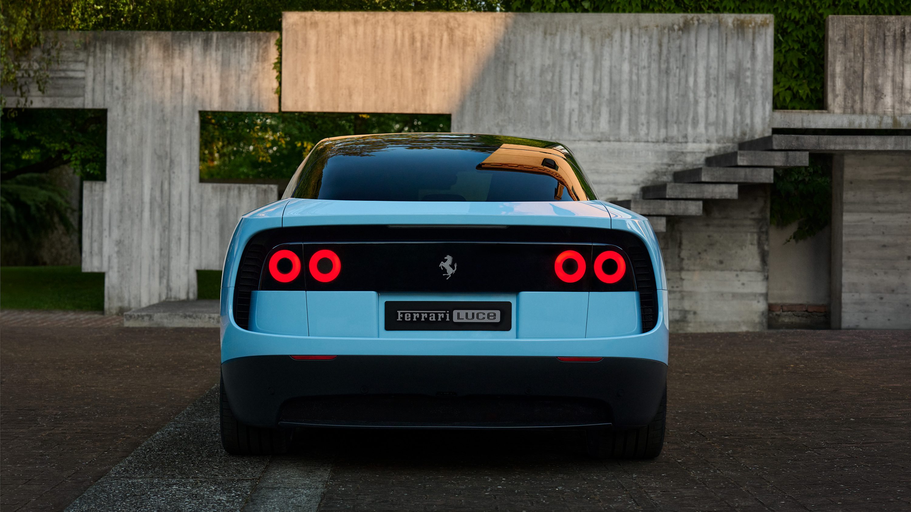2026 Ferrari Luce straight-on rear view showing the halo tail lights, floating aero wing, and clean shell-like rear surfaces