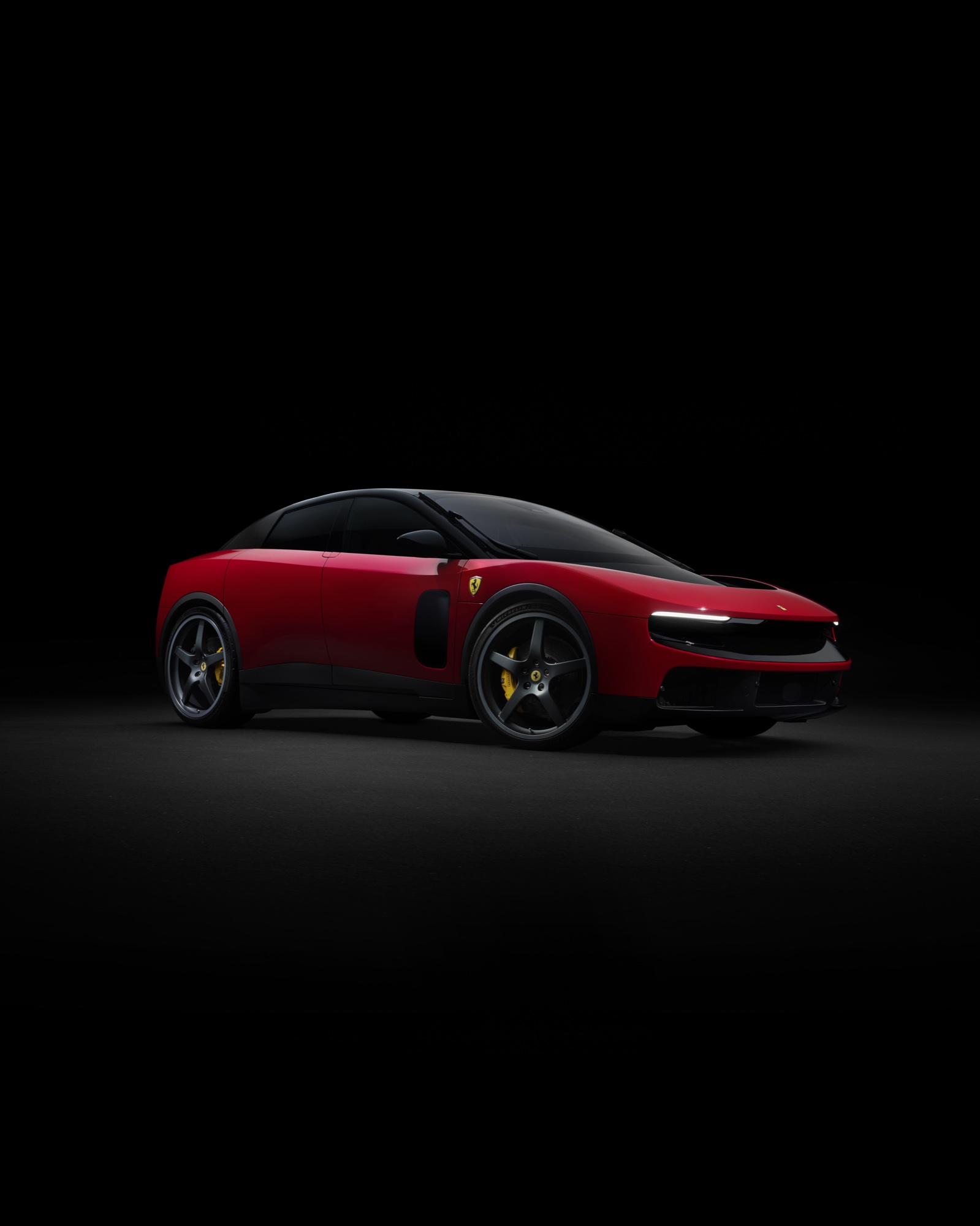 2026 Ferrari Luce front three-quarter view in Rosso Dino red with the front light panels illuminated