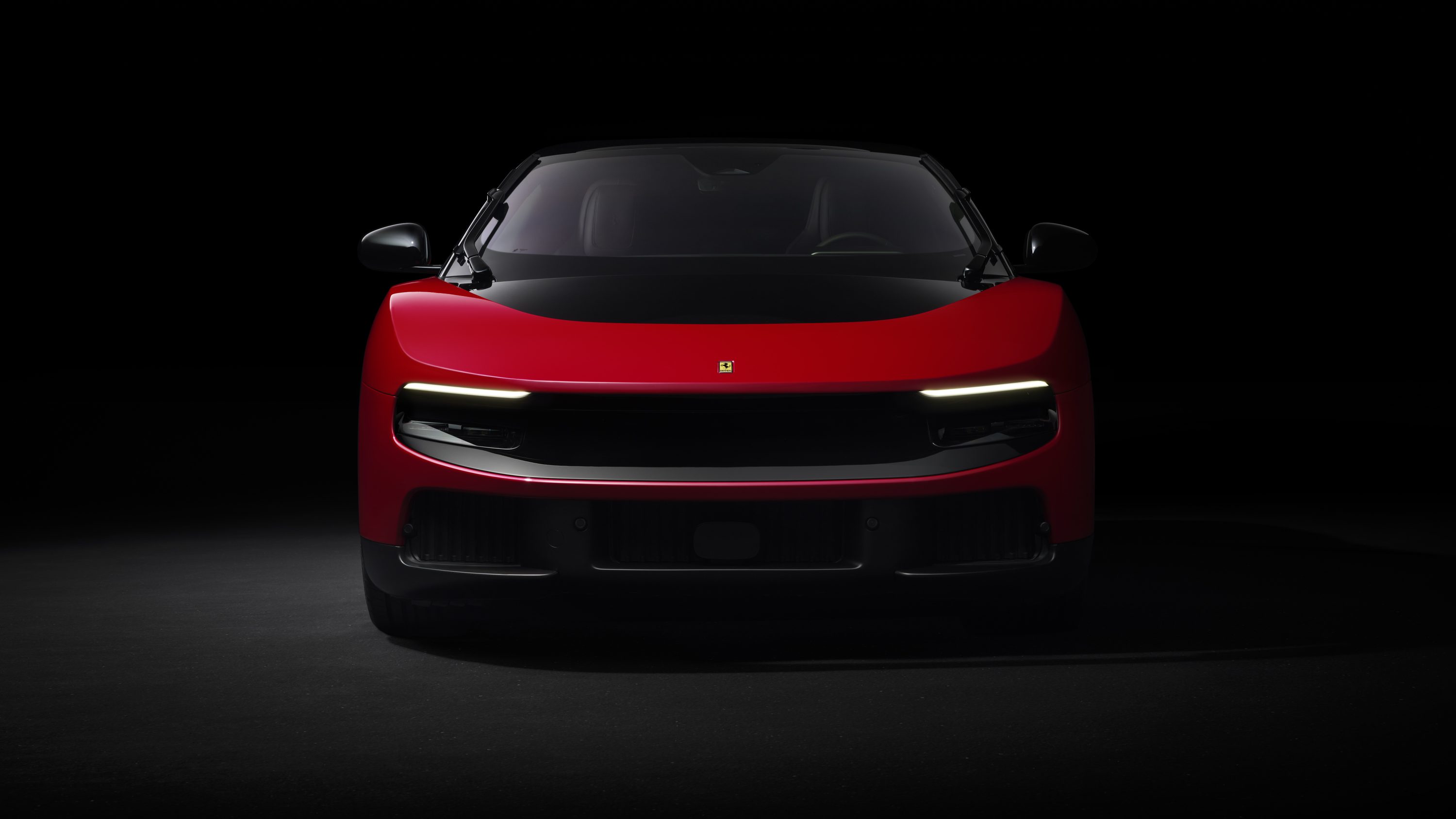 2026 Ferrari Luce in studio lighting with headlights illuminated, showing the transparent front light panel design