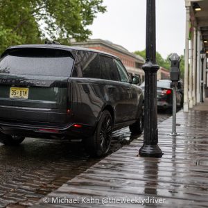2026 Range Rover SE SWB P400 in Belgravia Green parallel parked on a rain-soaked Old Sacramento street, rear three-quarter view
