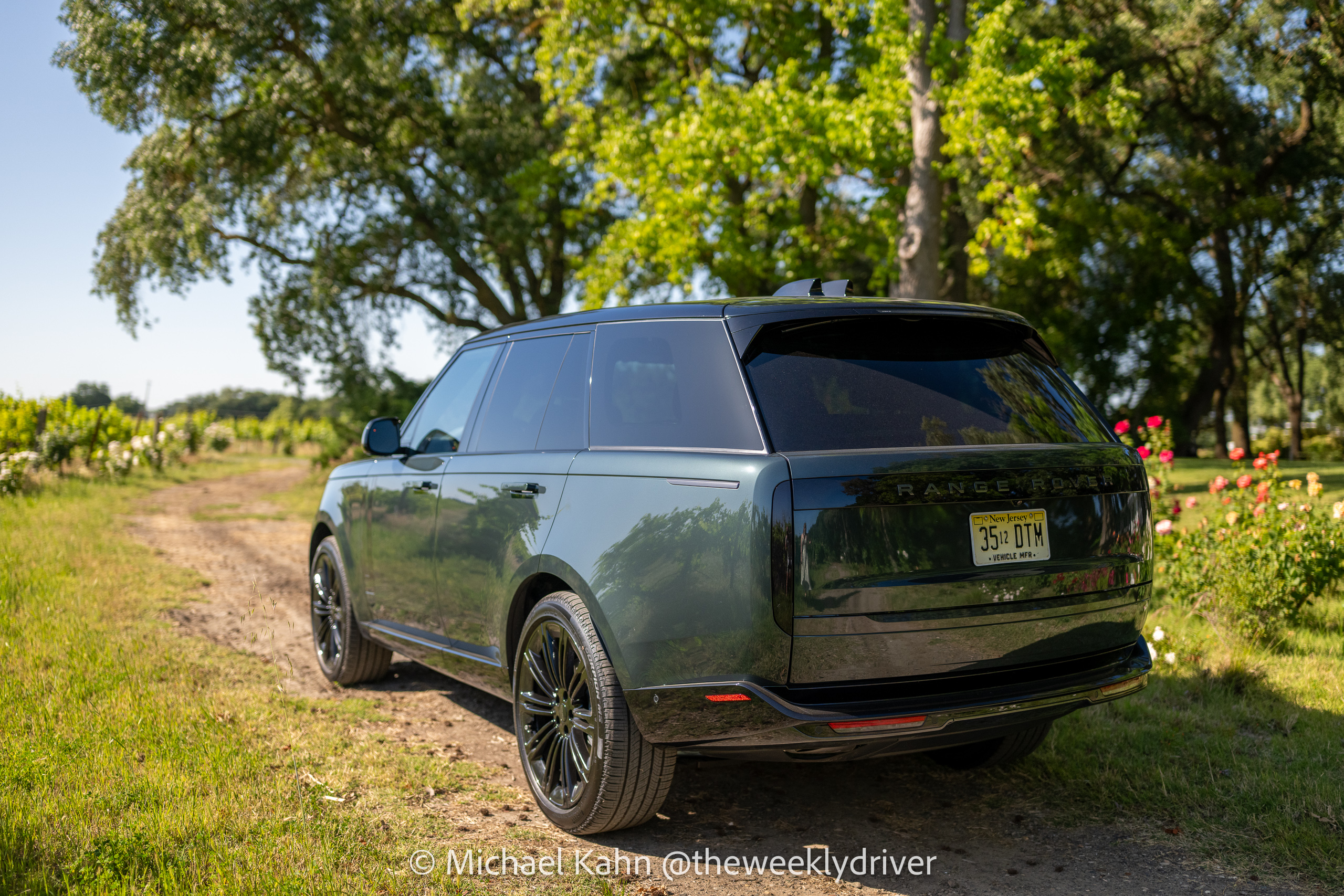 2026 Range Rover SE SWB P400 in Belgravia Green parked on a dirt track at a vineyard, rear three-quarter view in golden-hour light