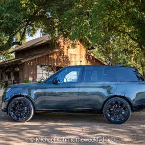 2026 Range Rover SE SWB P400 in Belgravia Green, side profile parked at a barn under oak trees in golden-hour light