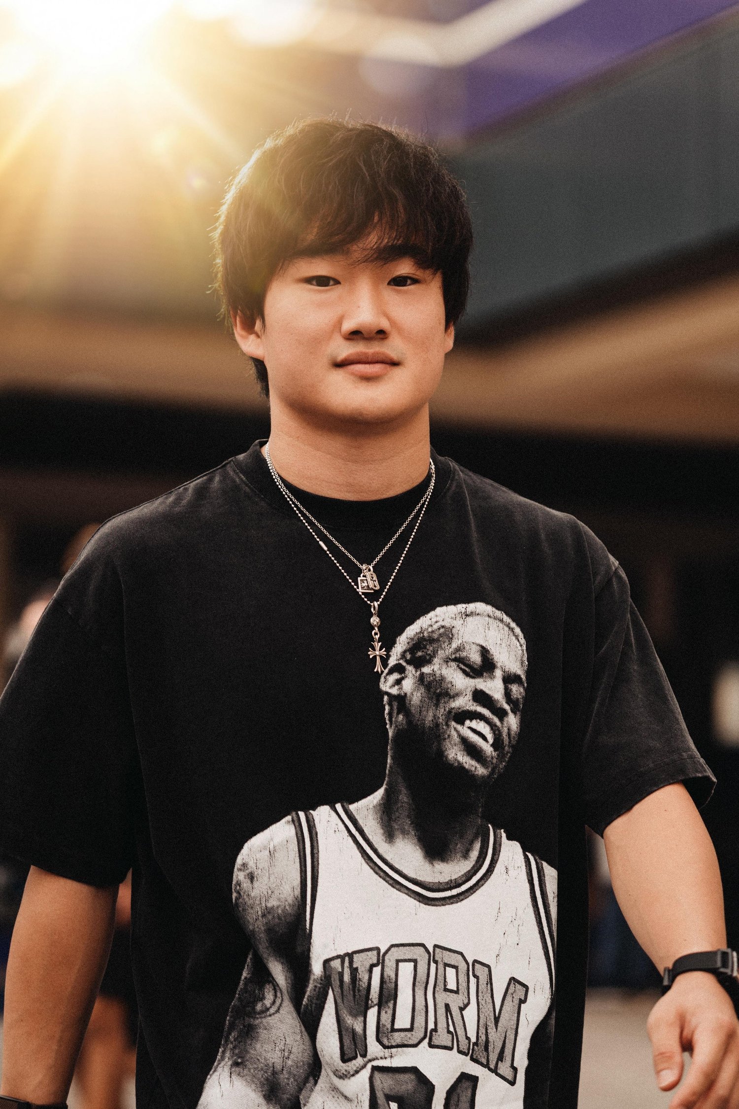 Velocity Invitational 2026: A Vintage Racing Festival at Sonoma With Tsunoda Saturday, Block Sunday, and a Sung Kang Drift Premiere Friday 5 Yuki Tsunoda in a vintage Dennis Rodman Worm t-shirt with sun flare behind him, ahead of his Saturday appearance at Velocity Invitational