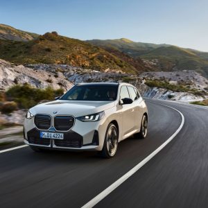 A white 2025 BMW X3 driving on a mountain road, the model that helped BMW lead US luxury sales in 2026