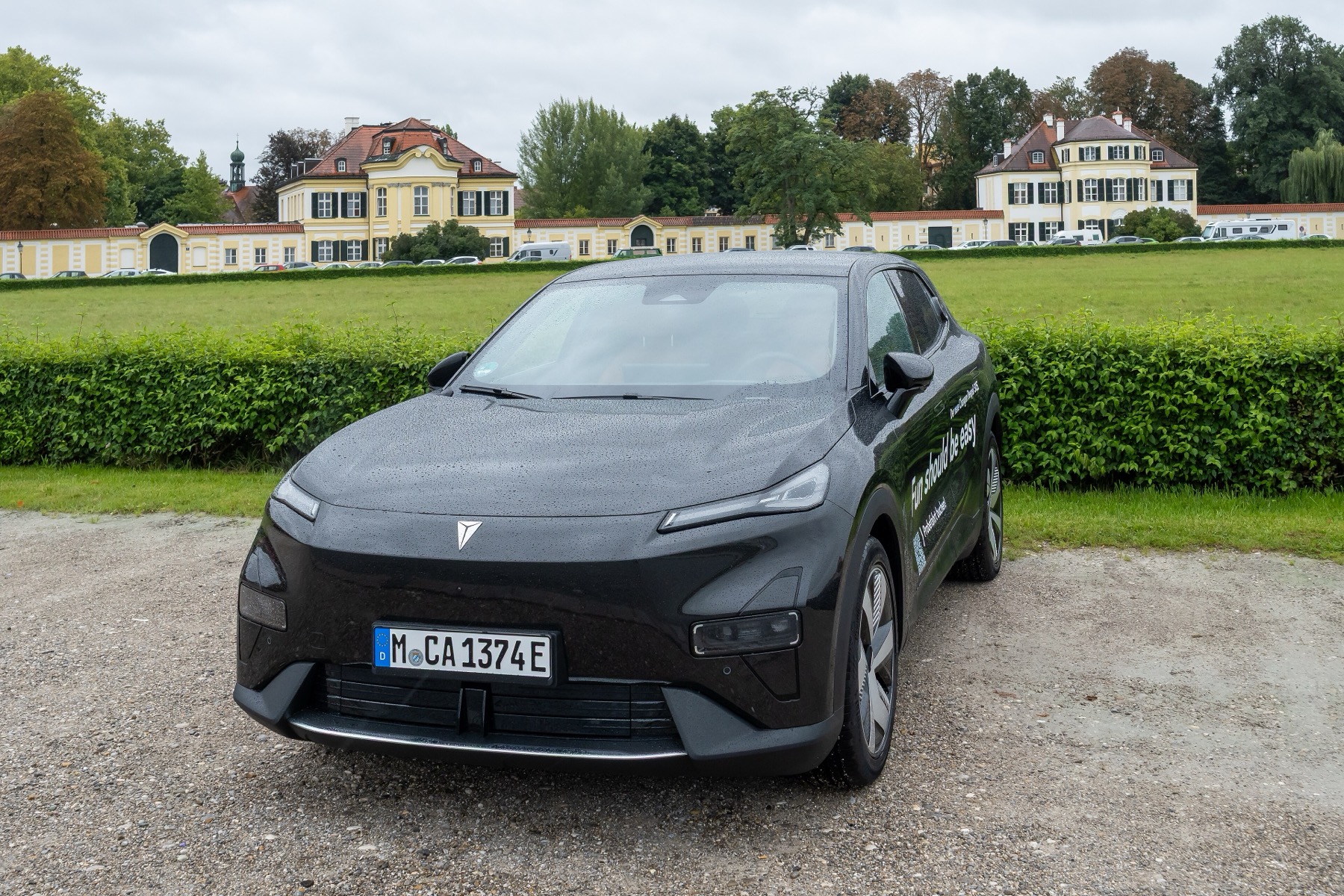 A black Changan Deepal S05 with German registration parked in front of a Bavarian palace