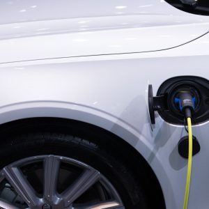 Electric vehicle plugged into a home charger at dusk, illustrating real-world EV battery degradation data for used-car buyers