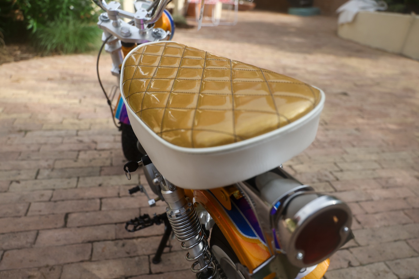Hand-sewn gold metal-flake diamond-stitched seat with white piping on the Hemmings Stay Gold custom CT-70 minibike