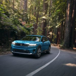 A blue Honda Prologue electric SUV driving on a forest road, the model Honda will discontinue after the 2026 model year