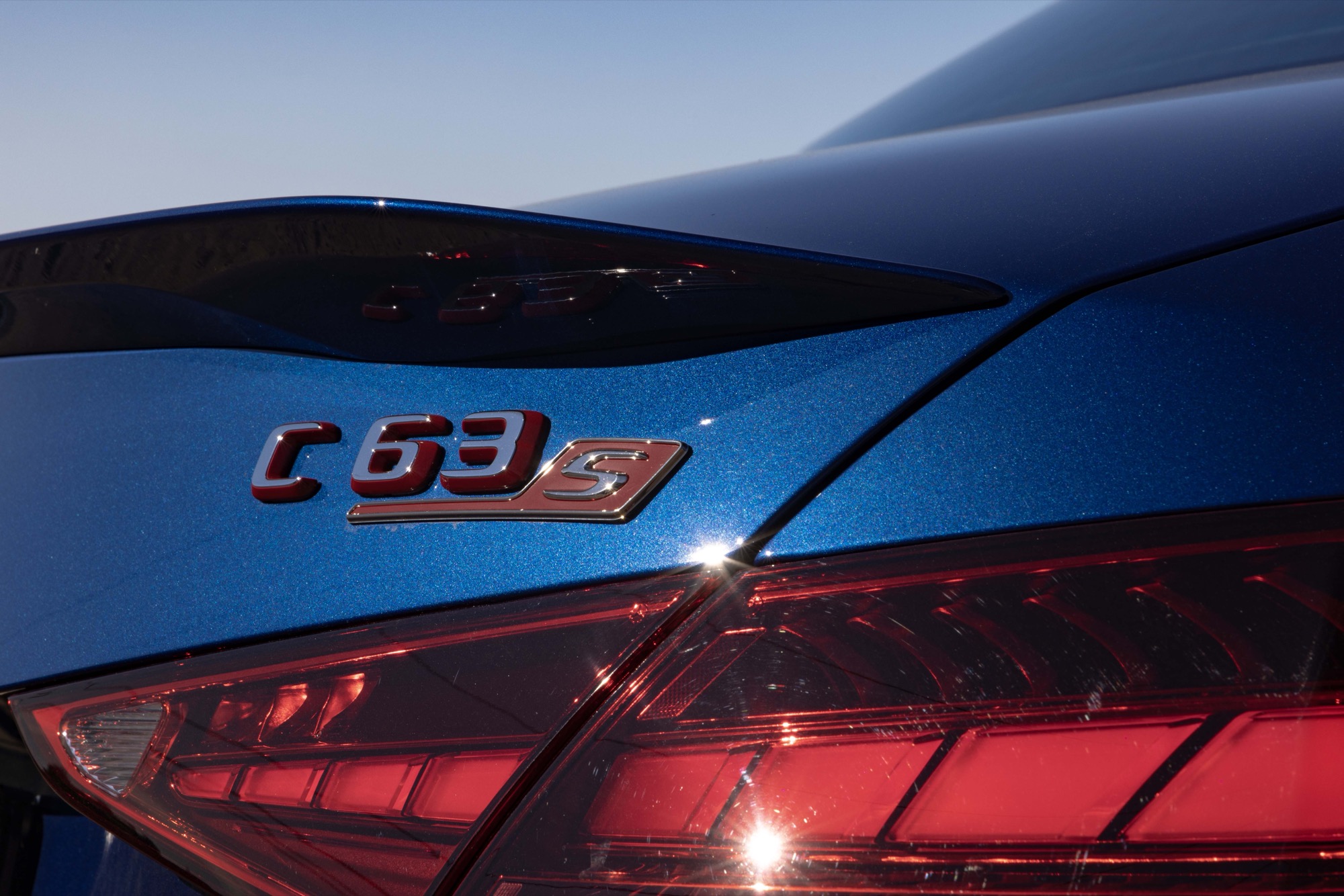 The C 63 S badge on the rear of a blue Mercedes-AMG sedan, beside the taillight