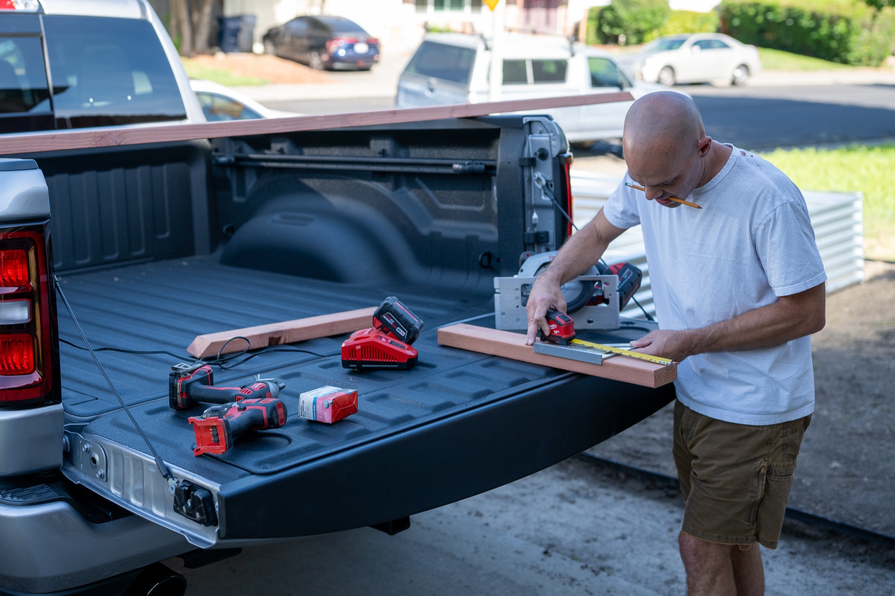 Loading lumber and tools into the bed of a 2026 RAM 1500 Express with spray-in liner
