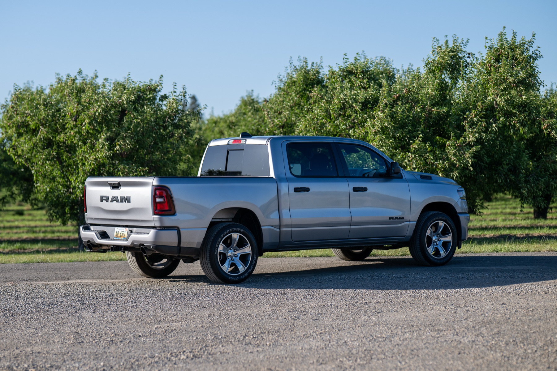 2026 RAM 1500 Express Billet Silver: Rear three-quarter in the orchard
