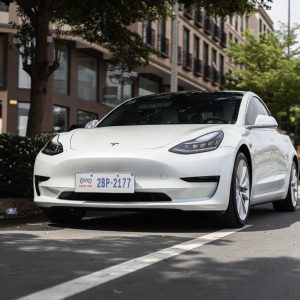 White Tesla Model 3 front three-quarter parked on a city street