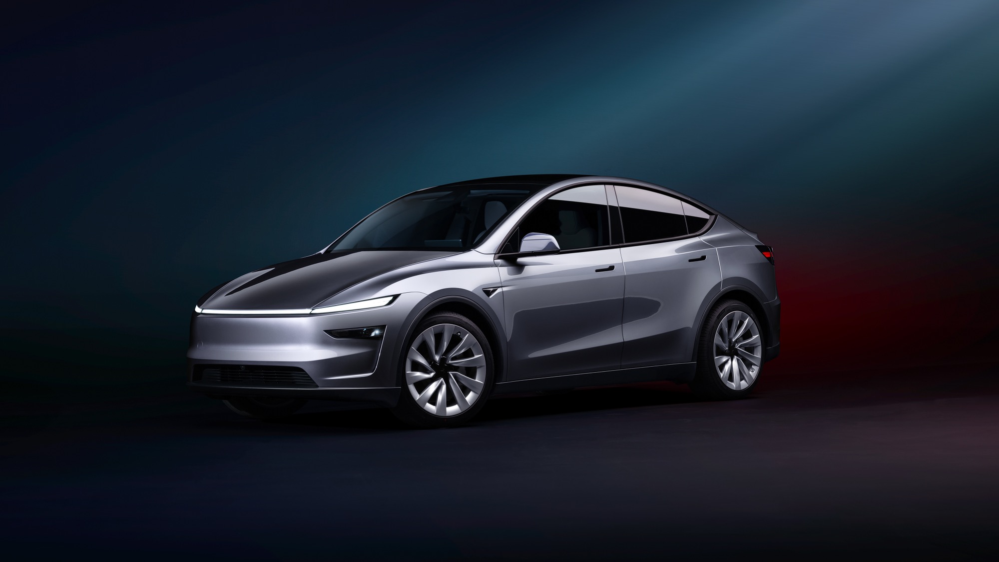 A silver 2026 Tesla Model Y Premium on a dark studio background