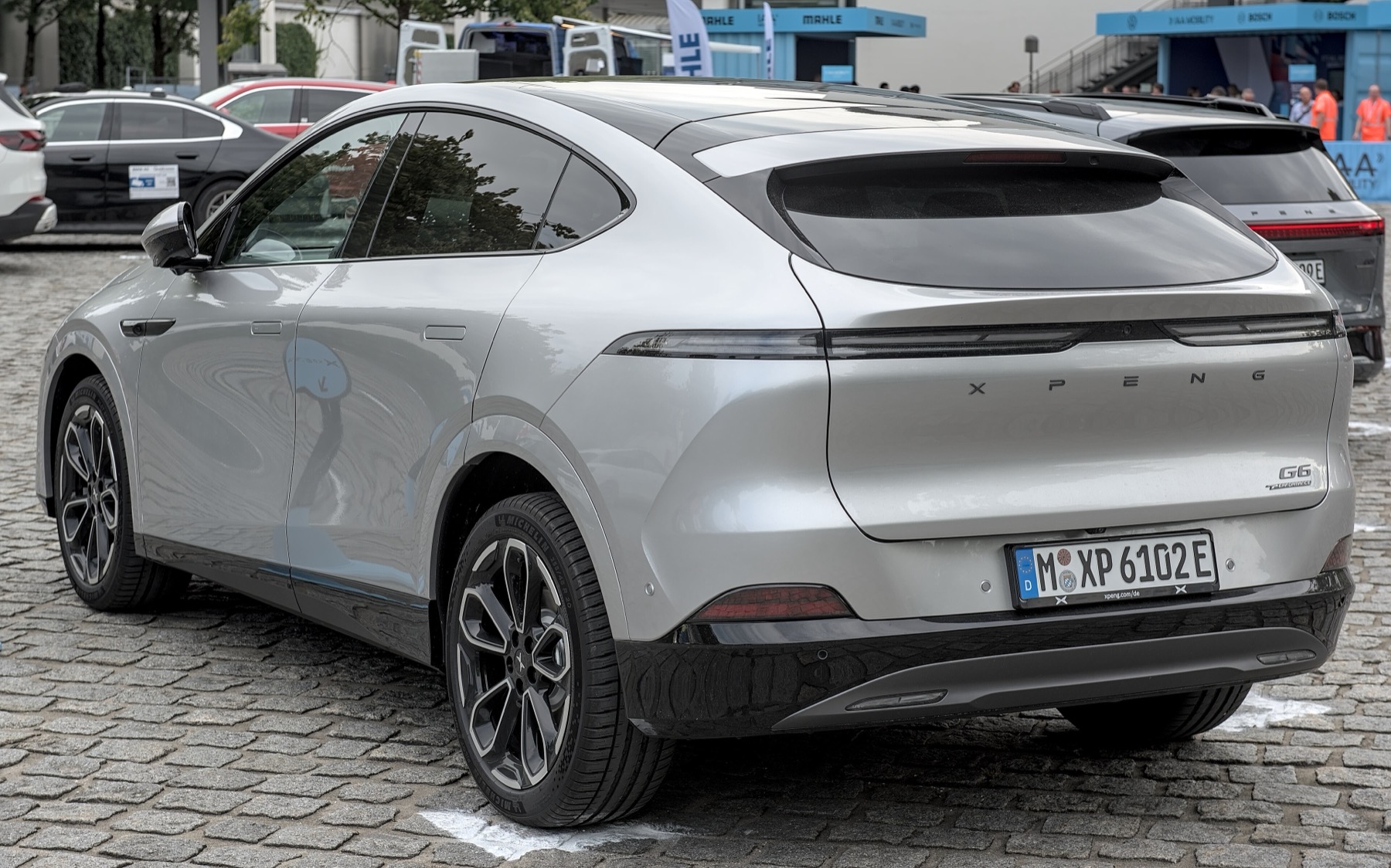 An XPeng G6 electric SUV on German license plates parked on a cobblestone street in Munich
