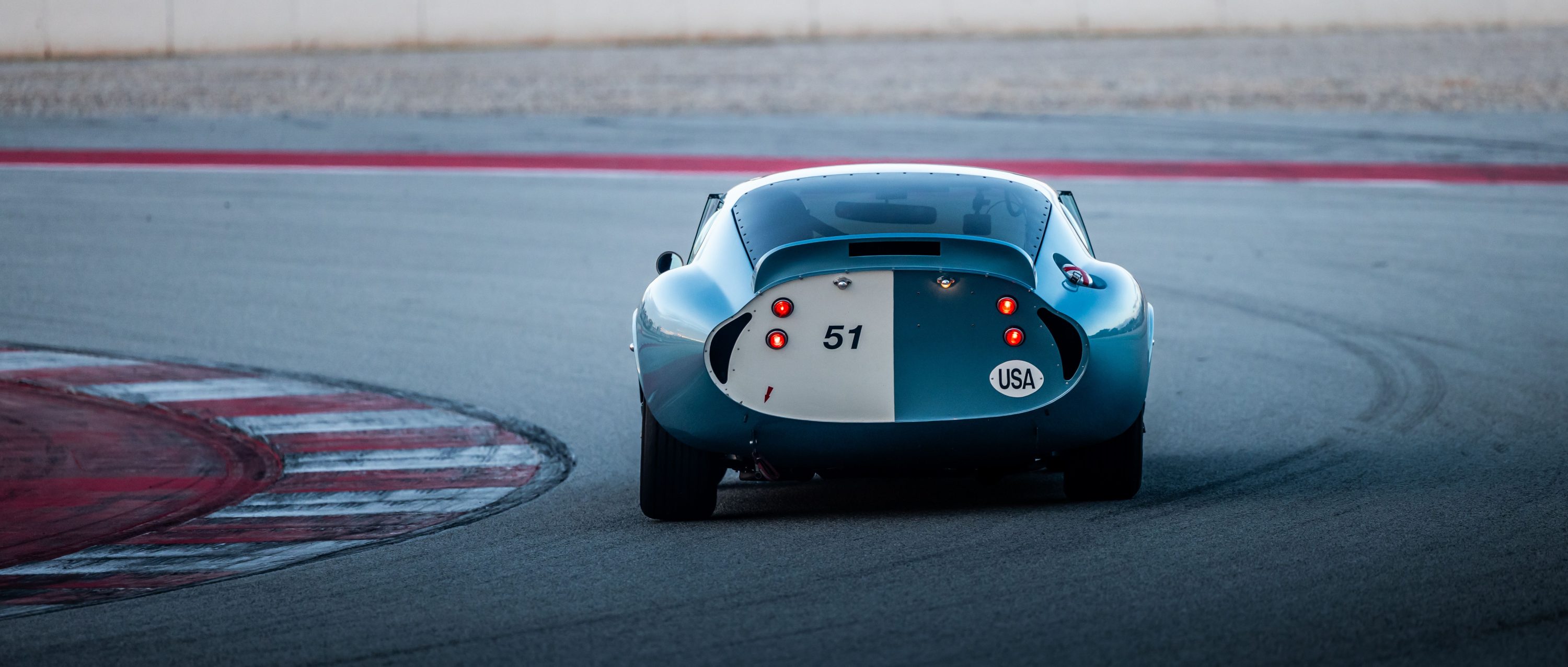 Vintage racing car on a track curve at dusk
