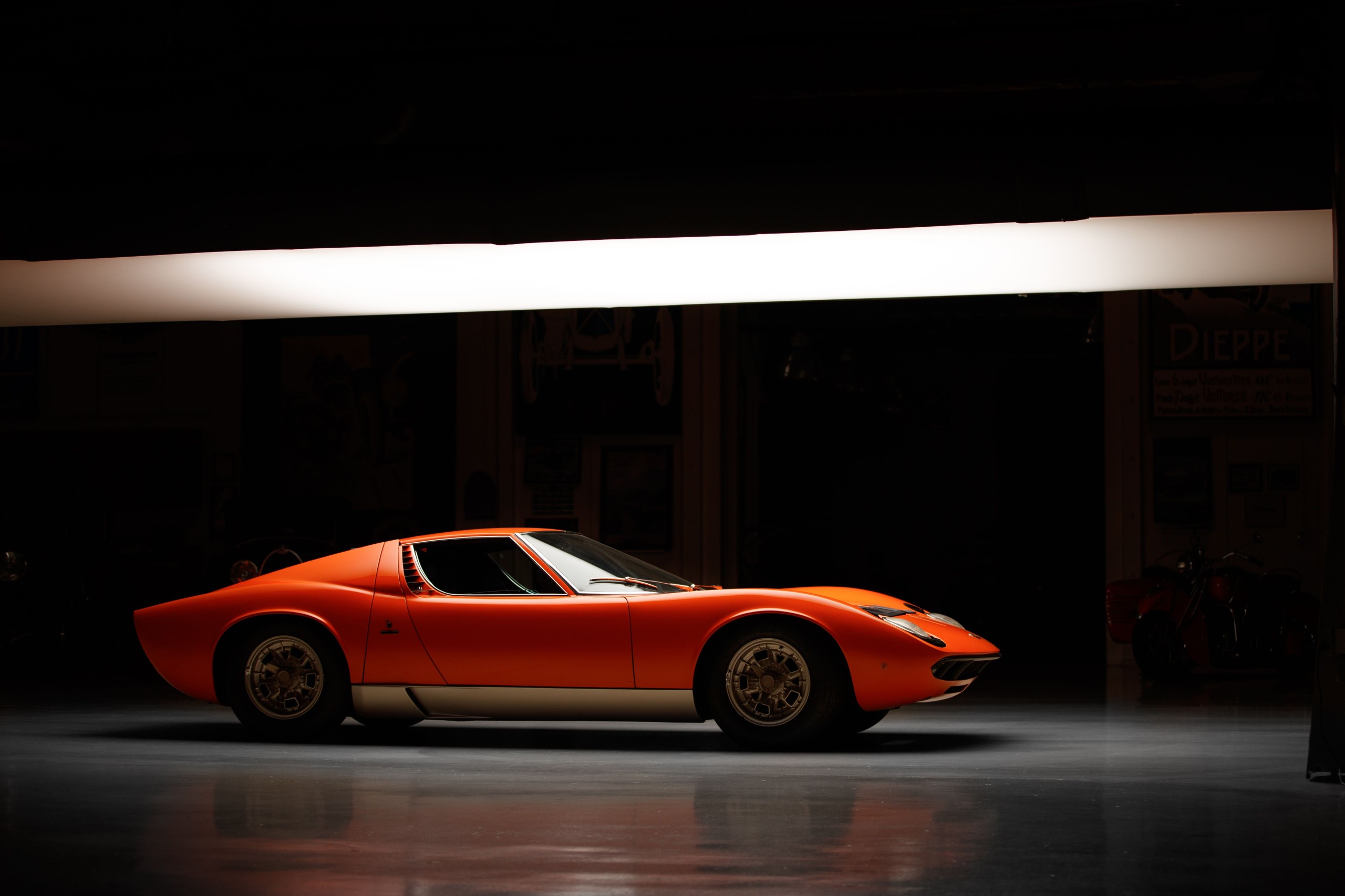Side profile of a vintage Lamborghini Miura under studio lighting