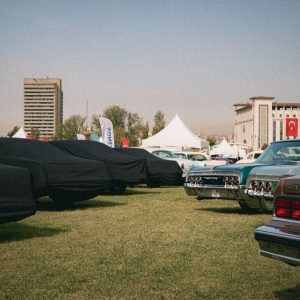 Row of classic collector cars staged at an indoor automotive display