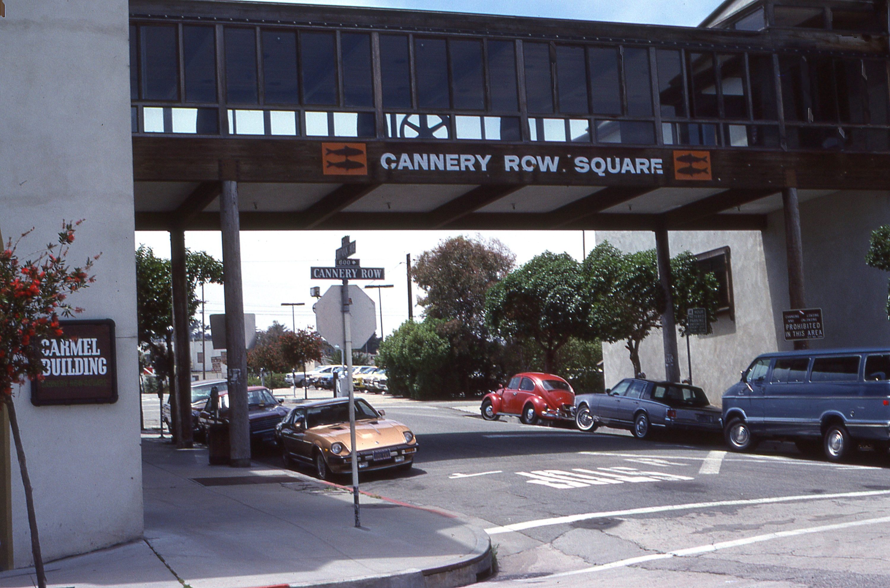 Classic cars parked in a row under a bridge on Cannery Row in Monterey