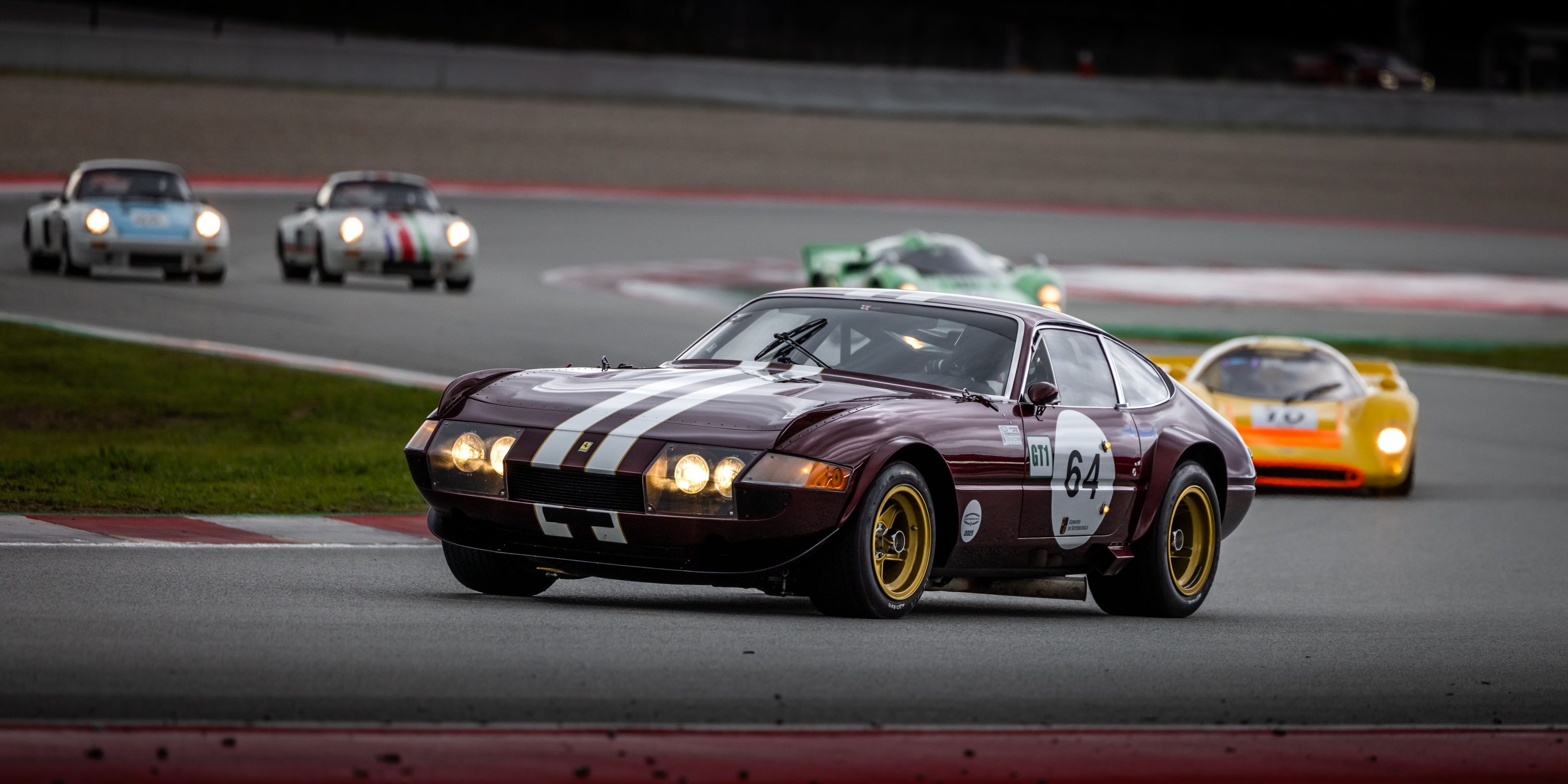 Vintage sports cars racing wheel to wheel on a road course