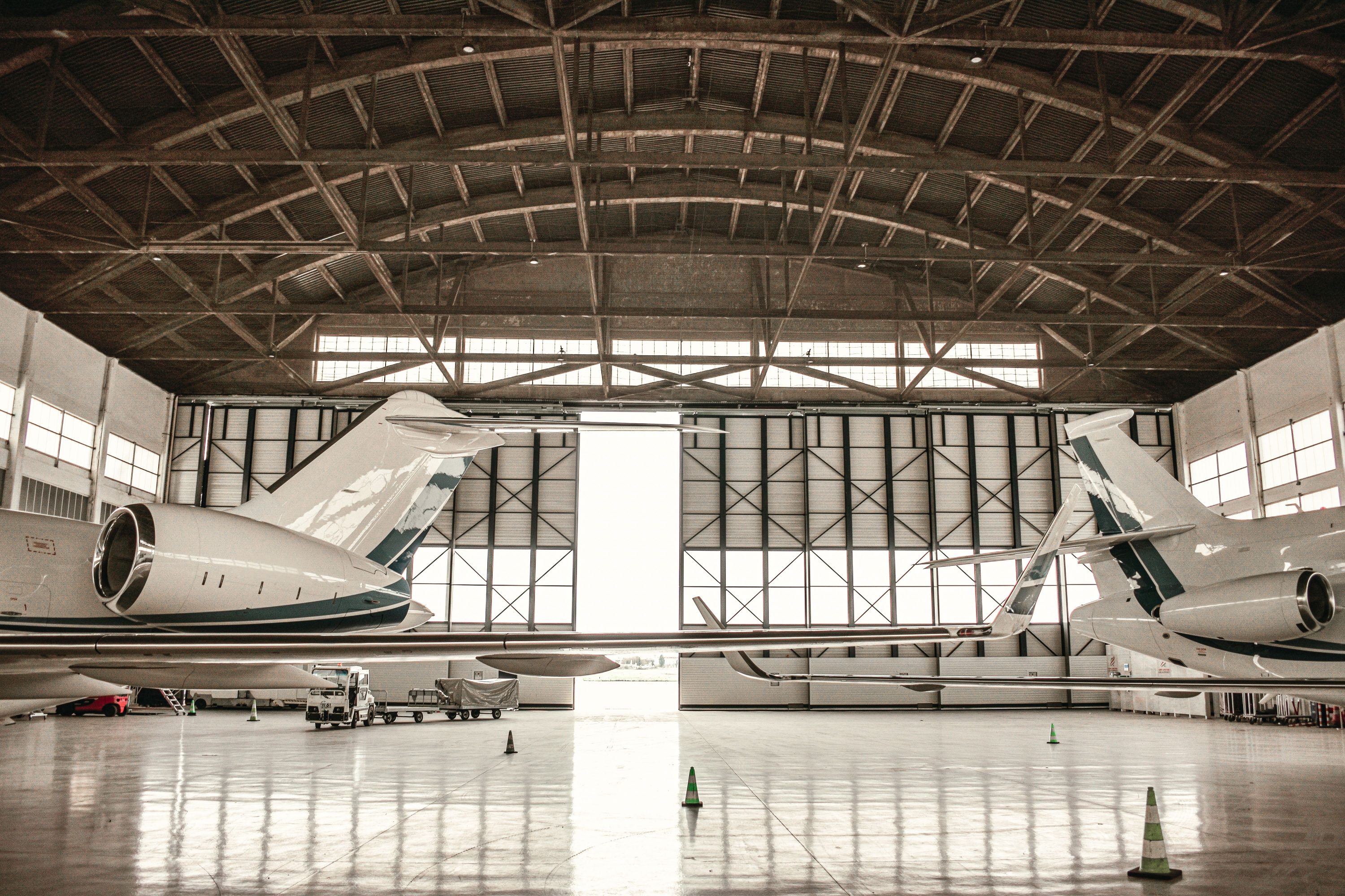 Private jets parked inside a large aircraft hangar