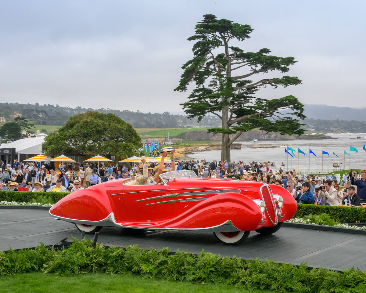 Red 1938 Delahaye 165 Figoni et Falaschi Cabriolet with enclosed fenders on the Pebble Beach awards ramp