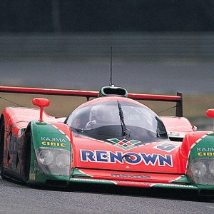 1991 Mazda 787B Group C prototype in orange and green Renown livery on the Le Mans circuit
