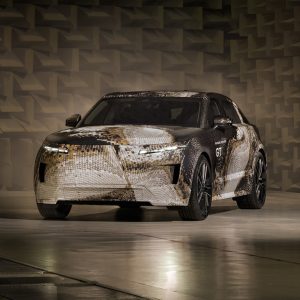 Camouflaged Range Rover GT prototype in gold topographic wrap photographed inside an acoustic test chamber, front three-quarter view