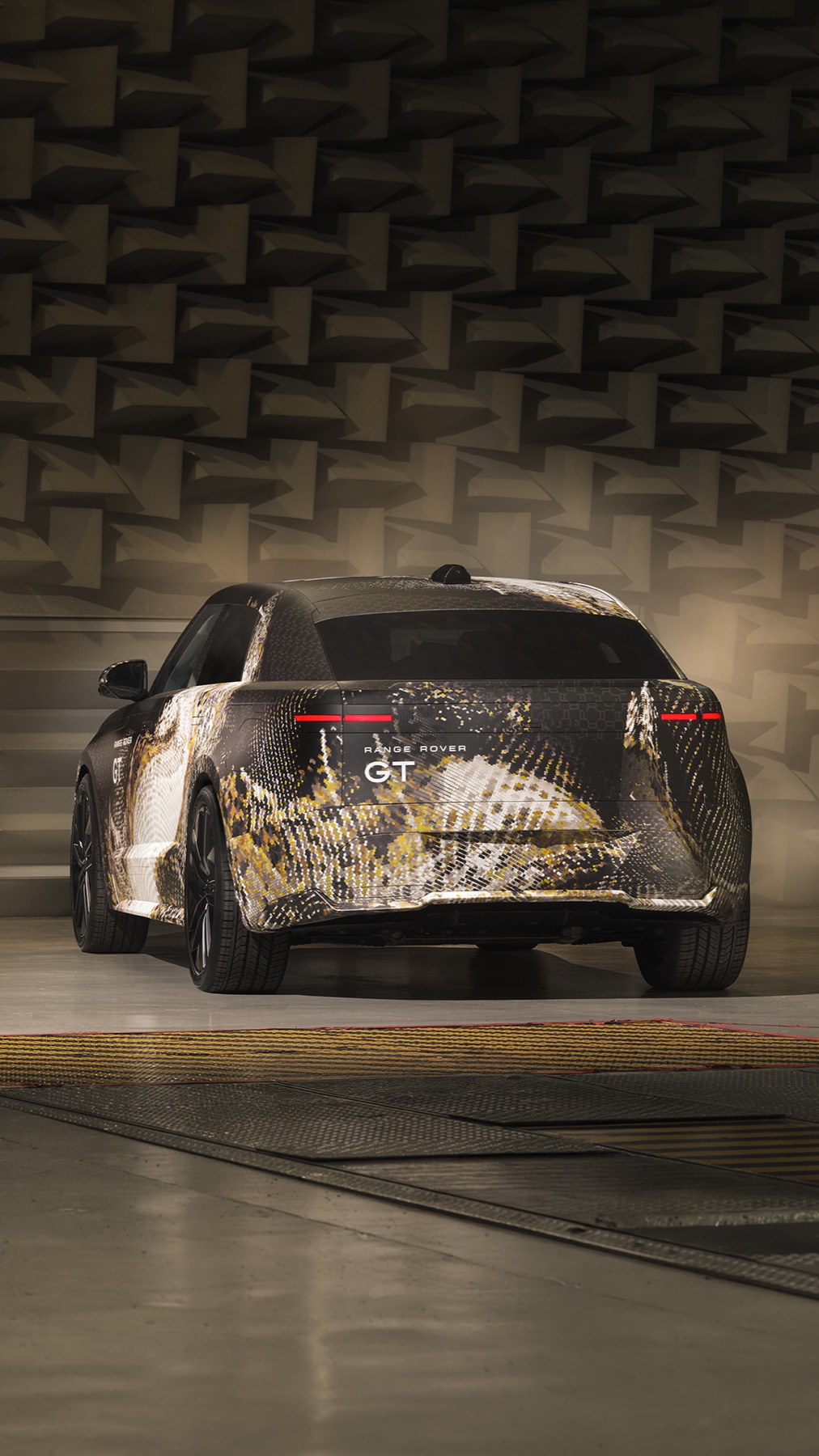 Rear view of the camouflaged Range Rover GT prototype showing the split LED tail lamps and GT badge across the tailgate