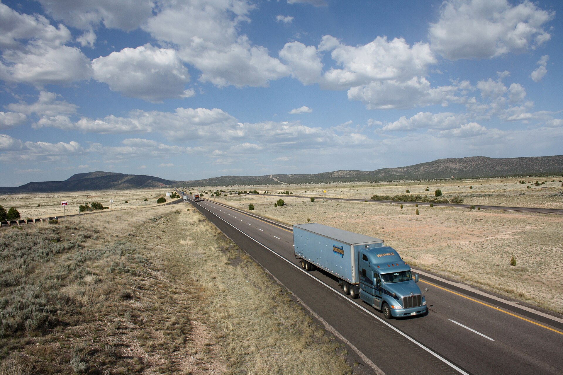 A Werner combination tractor-trailer travelling an Arizona interstate highway with long open sight lines through high desert terrain