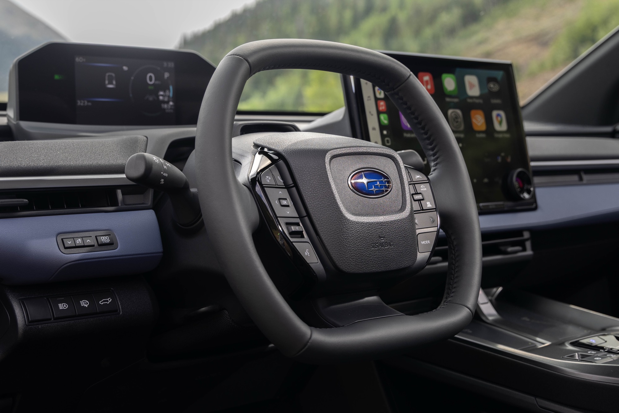 Interior of a 2026 Subaru Solterra showing the 14-inch touchscreen, steering wheel and 7-inch instrument display