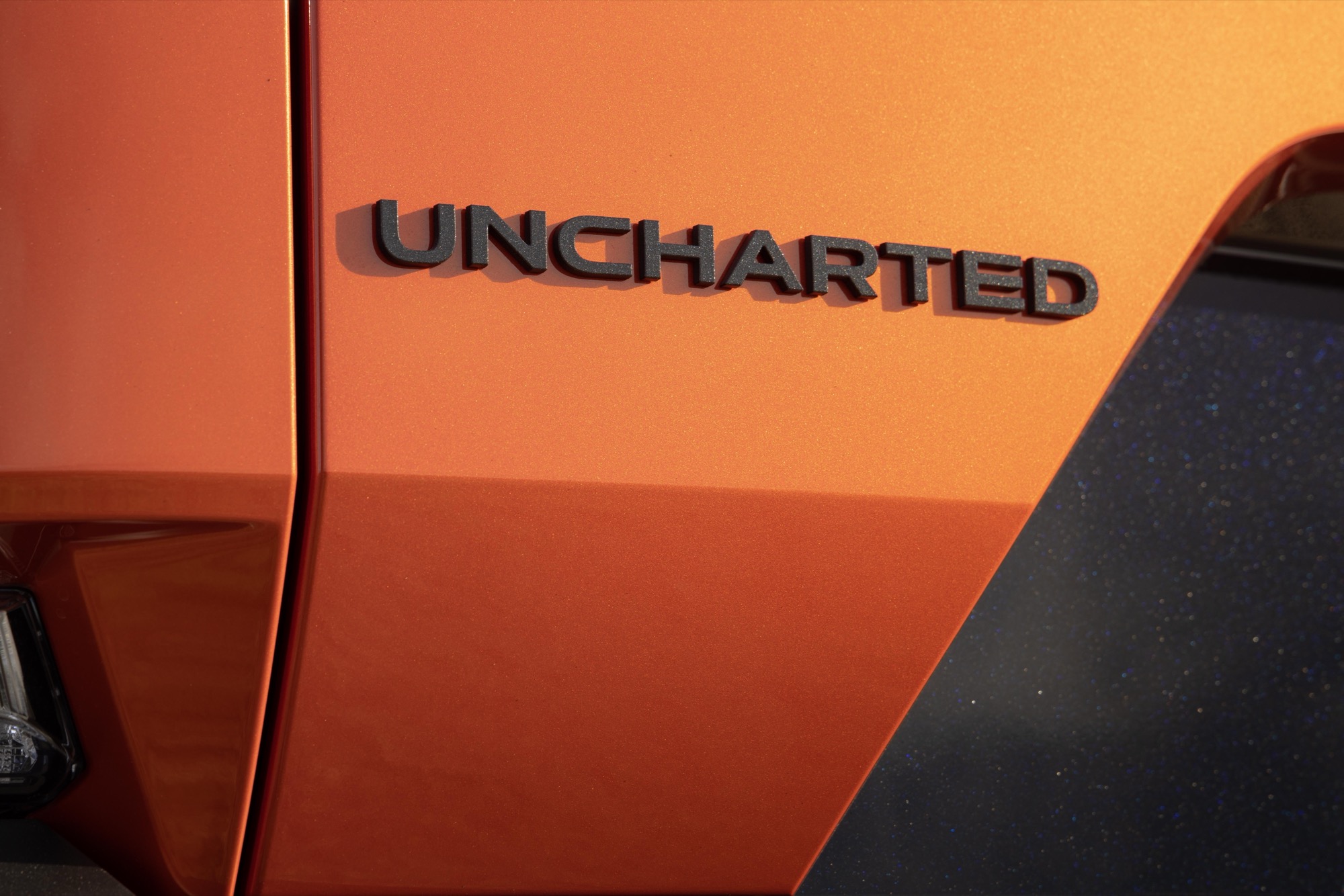 Close-up of the Uncharted badge on the orange rear quarter panel of a 2026 Subaru Uncharted