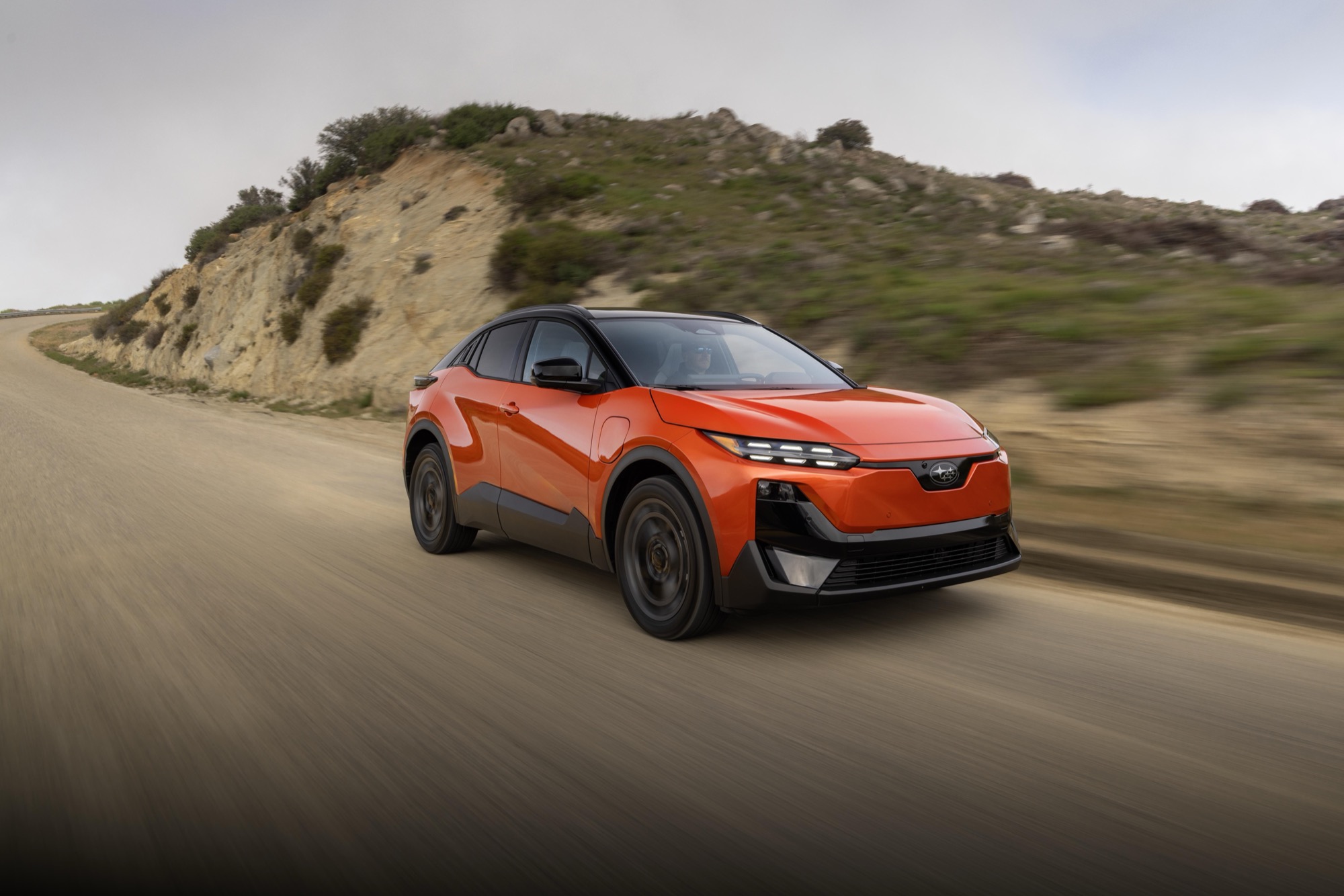 2026 Subaru Uncharted driving on a coastal road, front three-quarter view in motion