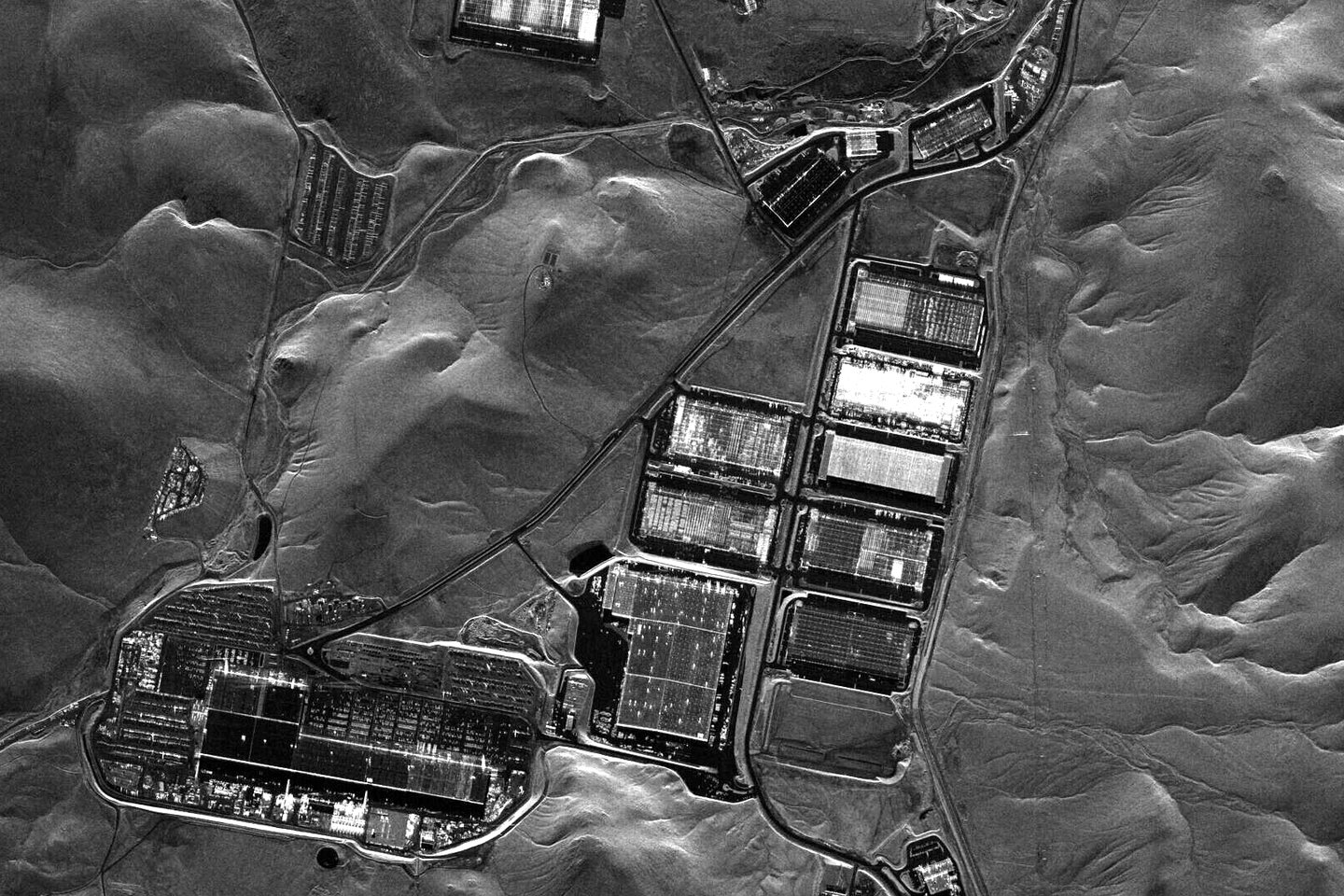 Radar satellite image of the Gigafactory Nevada complex at the Tahoe-Reno Industrial Center, showing the main factory and a row of newer buildings in the surrounding hills