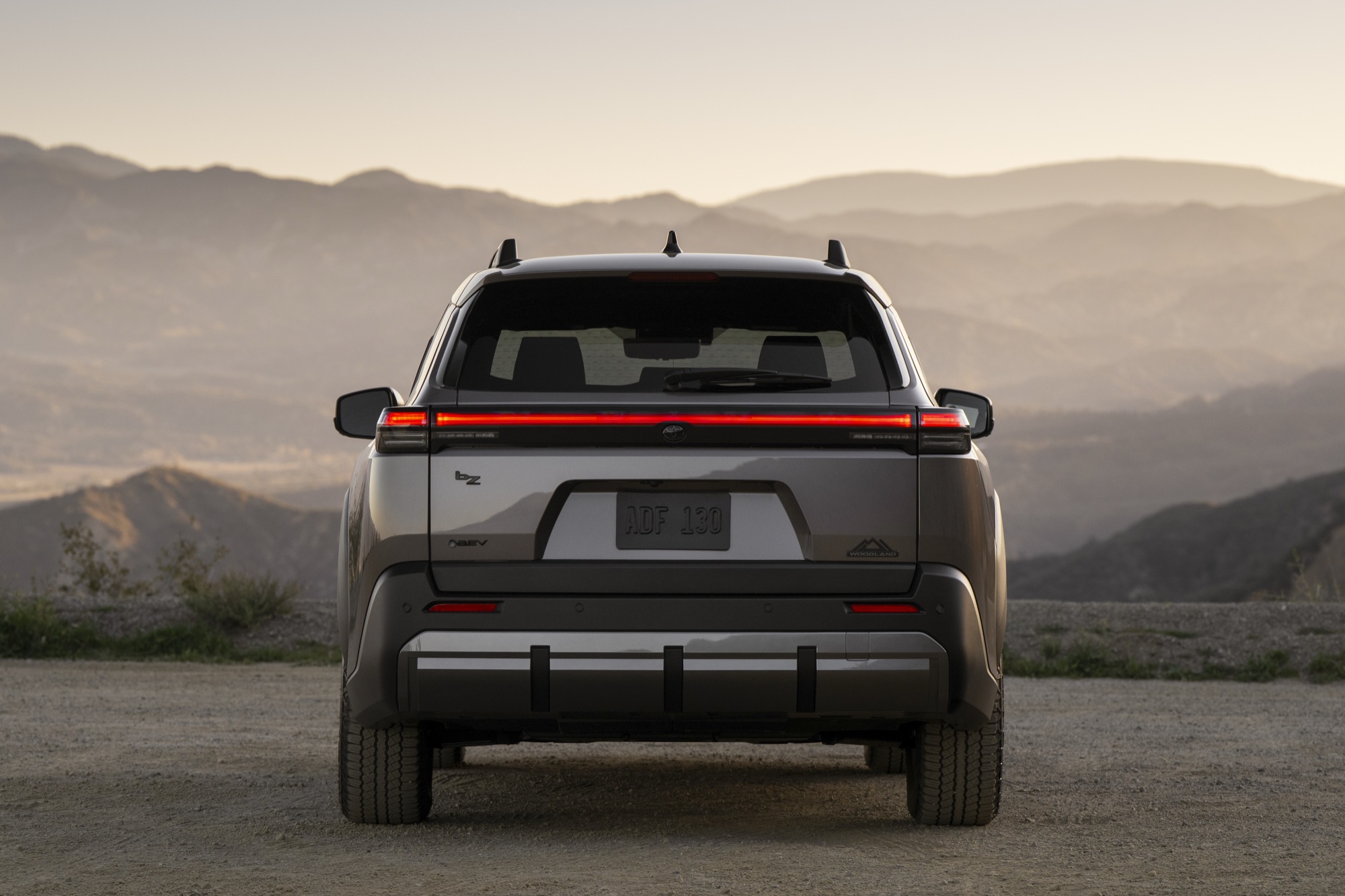 Rear view of a 2026 Toyota bZ Woodland showing the full-width light bar and power liftgate