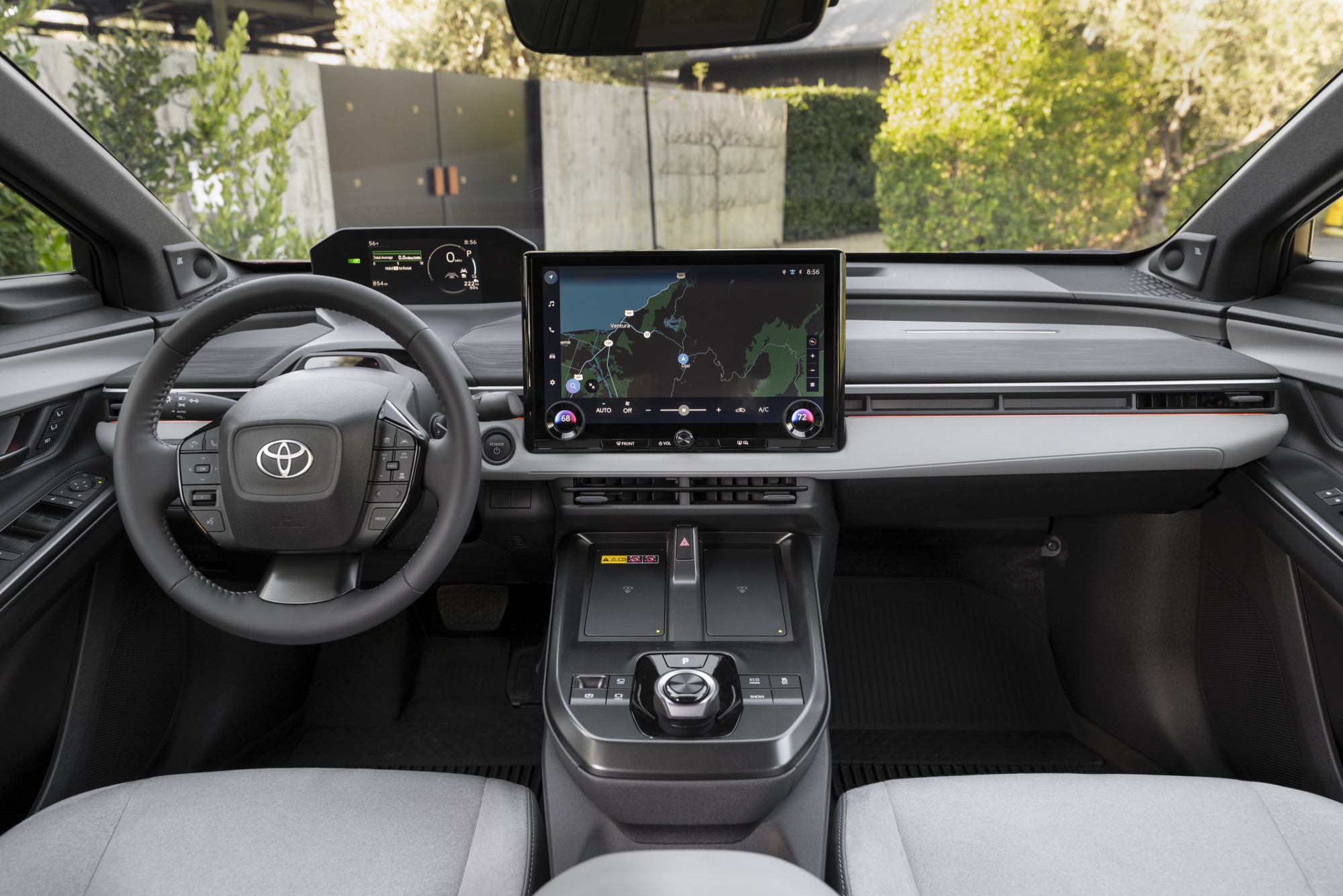 Interior of the 2026 Toyota C-HR BEV showing the touchscreen, steering wheel and light grey upholstery